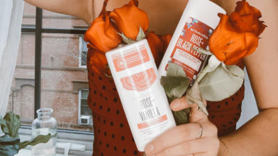 Girl in red polka dot shirt holding roses and Schmidt's Rose+Vanilla and Rose+Black Pepper deodorant sticks